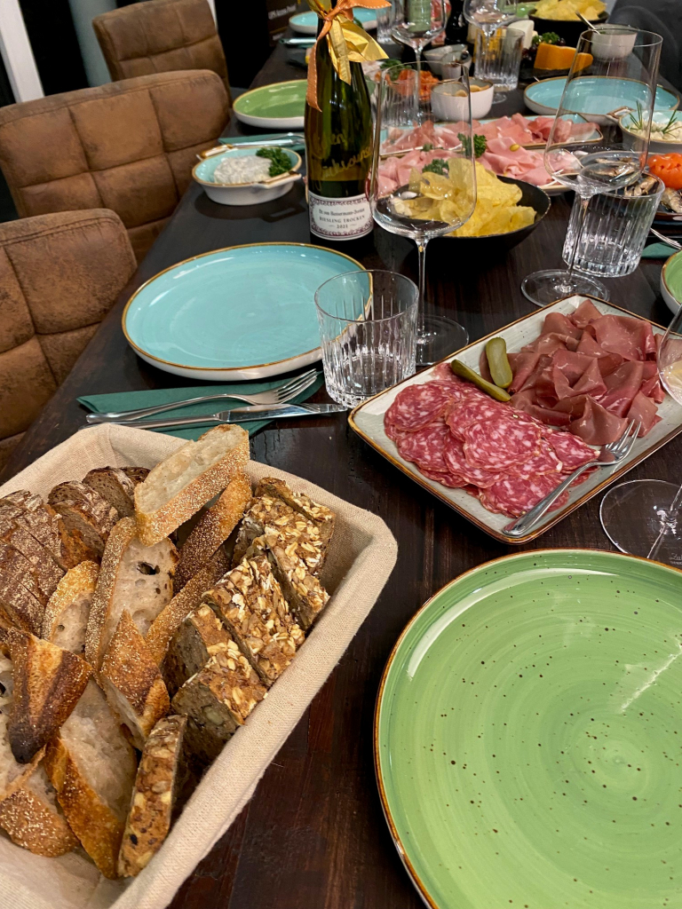 Weinrunde mit Brot, Wurst und Käse am gedeckten Tisch