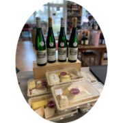 Riesling-Flaschen und Käsepakete im Weinladen