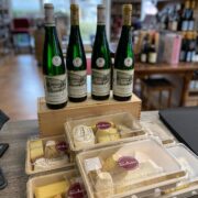 Riesling-Flaschen und abgepackte Käsepakete auf dem Ladentisch