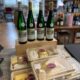 Riesling-Flaschen und abgepackte Käsepakete auf dem Ladentisch